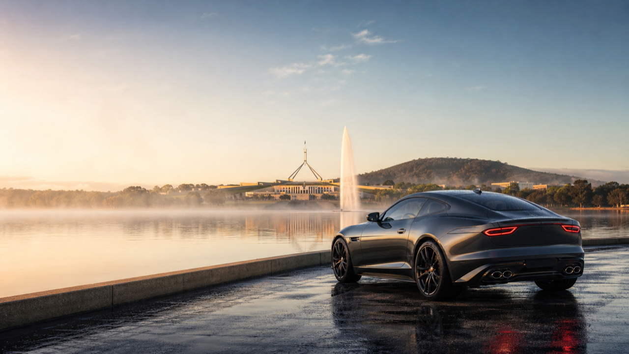 A car by Lake Burley Griffin with Parliament House in Canberra